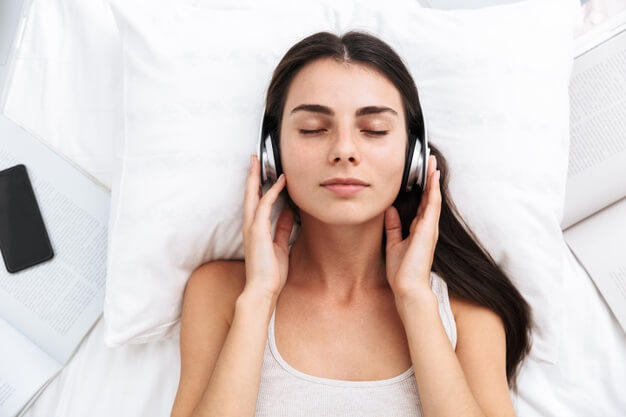 mujer acostada escuchando música