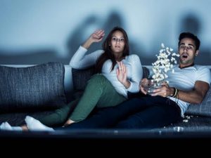 chica y chico asustados viendo television