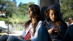 dos amigas compartiendo audifonos
