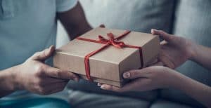 expresa tus sentimientos las manos de una chica dándole un regalo a un hombre
