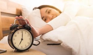 Mujer feliz apagando la alarma al despertar